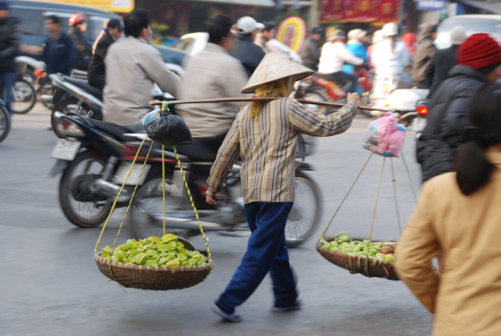 Header image on Independent Travel Agencies webpage showing a man in a market carrying baskets of fruit.
